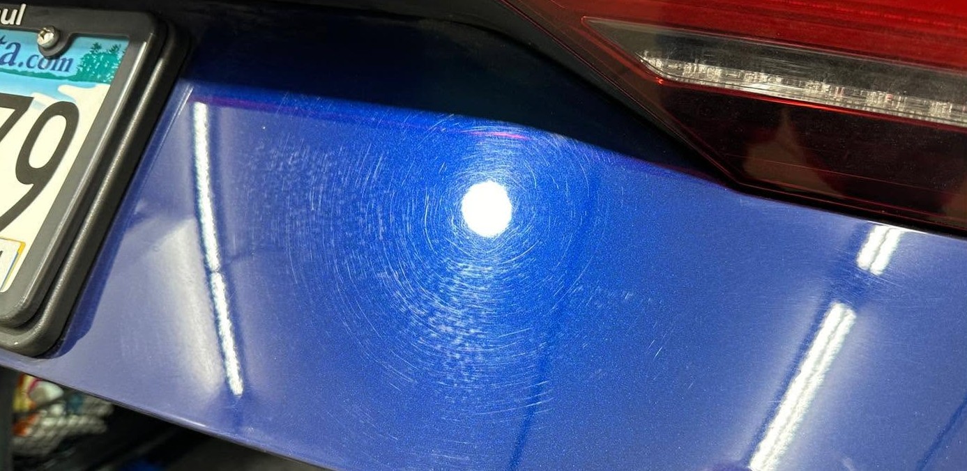Metallic blue paint with swirl marks before correction